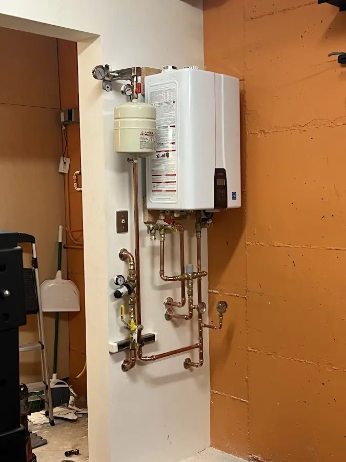Plumbing technician inspecting water heater connections in East Richmond Heights